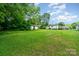 Expansive backyard featuring a storage shed, mature trees and back house view at 511 W Finger St, Maiden, NC 28650