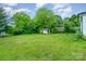Large grassy backyard with a storage shed and mature trees at 511 W Finger St, Maiden, NC 28650