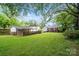 Extensive backyard featuring lush green grass, mature trees, and a variety of structures and fences at 512 Forest Ln, Rock Hill, SC 29730