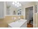 Bright bathroom featuring a white sink vanity, a large mirror with lighting and a glimpse of the shower at 512 Forest Ln, Rock Hill, SC 29730