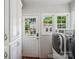 Bright laundry area with modern appliances, ample cabinet space, and a door leading outside at 512 Forest Ln, Rock Hill, SC 29730