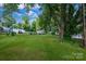 Spacious backyard offers a lush lawn with mature shade trees at 5715 Coulee Pl, Charlotte, NC 28217