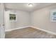 Bright bedroom with wood-look flooring, two windows, and fresh neutral paint at 5715 Coulee Pl, Charlotte, NC 28217