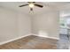Bright living room featuring modern wood flooring, ceiling fan, and access to kitchen at 5715 Coulee Pl, Charlotte, NC 28217