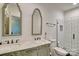 Bathroom featuring double sinks, decorative mirrors, and tiled walk-in shower at 6650 Highway 341 Hwy, Kershaw, SC 29067