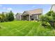 Well-maintained backyard with lush green grass, a patio area, and mature landscaping at 7016 Bareland Rd, Fort Mill, SC 29707