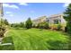 Expansive backyard featuring well-manicured lawn, mature trees, and privacy fencing at 7016 Bareland Rd, Fort Mill, SC 29707