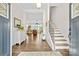 Spacious foyer with hardwood floors, a staircase, and views into the living and dining areas at 7016 Bareland Rd, Fort Mill, SC 29707