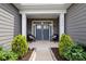 Inviting front porch with seating, decorative plants, and stone accents around the entrance at 7016 Bareland Rd, Fort Mill, SC 29707