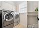 Laundry room features stainless steel washer and dryer, window and cabinet storage at 7016 Bareland Rd, Fort Mill, SC 29707
