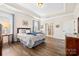 Cozy main bedroom features a tray ceiling, hardwood floors and an ensuite bathroom at 7016 Bareland Rd, Fort Mill, SC 29707
