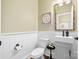 Charming powder room boasts wainscoting, wall art, and modern fixtures at 7016 Bareland Rd, Fort Mill, SC 29707