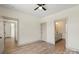 Bright bedroom with open door that leads to a bathroom, wood-look flooring, and a ceiling fan at 705 Sunderland Sw Rd, Concord, NC 28027