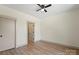 Bedroom features hardwood floors, closet, ceiling fan, and an open door to the stylish geometric-designed room at 705 Sunderland Sw Rd, Concord, NC 28027