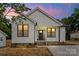 Charming home features white siding, black framed windows, and a covered front porch at 705 Sunderland Sw Rd, Concord, NC 28027