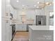 Bright kitchen with stainless steel appliances, white cabinets, an island and hardwood floors at 705 Sunderland Sw Rd, Concord, NC 28027