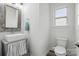 This bathroom features a modern sink with mirror, toilet, and window at 7166 Dove Field Ln, Fort Mill, SC 29707