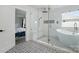 Elegant bathroom boasting a soaking tub, glass shower with rain head, and striking black-and-white patterned tile at 7166 Dove Field Ln, Fort Mill, SC 29707