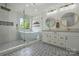Bright bathroom featuring a soaking tub, frameless glass shower, double vanity, and patterned tile flooring at 7166 Dove Field Ln, Fort Mill, SC 29707