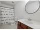 This bathroom features a round mirror, a tiled floor and a shower with a colorful curtain at 7166 Dove Field Ln, Fort Mill, SC 29707