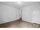 Well-lit room with wood-look flooring, neutral walls, and an open doorway at 7166 Dove Field Ln, Fort Mill, SC 29707