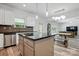Kitchen island featuring granite countertops, stainless appliances, and open access to the dining and living room at 7166 Dove Field Ln, Fort Mill, SC 29707