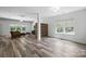 Open-concept living room with luxury vinyl flooring, large windows, and modern lighting at 7166 Dove Field Ln, Fort Mill, SC 29707