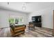 Comfortable living room featuring luxury vinyl flooring, a modern television, and a green couch at 7166 Dove Field Ln, Fort Mill, SC 29707