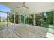An enclosed sunroom featuring hardwood floors, ceiling fan, and sliding glass doors overlooking mature trees at 7166 Dove Field Ln, Fort Mill, SC 29707