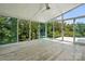 An enclosed sunroom featuring hardwood floors, ceiling fan, and sliding glass doors overlooking mature trees at 7166 Dove Field Ln, Fort Mill, SC 29707