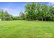 Expansive backyard, fully turfed with mature trees provides privacy at 806 N Central Ave, Locust, NC 28097