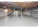 Large, unfinished basement with exposed beams, ductwork, and staircase at 806 N Central Ave, Locust, NC 28097