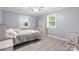 Staged bedroom with neutral tones, featuring wood floors, dresser, ceiling fan, and natural light at 806 N Central Ave, Locust, NC 28097