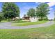 Charming single-story home with a large wooden deck, a two-car garage and a circular driveway surrounded by large trees at 806 N Central Ave, Locust, NC 28097
