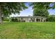 Well-maintained one-story home with a lush green lawn, mature shade trees, and tasteful landscaping at 806 N Central Ave, Locust, NC 28097