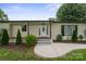 Inviting front entrance with a decorative door, manicured landscaping, and modern concrete walkway and porch at 806 N Central Ave, Locust, NC 28097