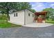 Backyard with a covered wooden patio, perfect for outdoor entertaining, and a concrete walkway to the home at 806 N Central Ave, Locust, NC 28097