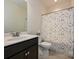 Bathroom featuring a dark wood vanity, a toilet, and a shower-tub combo with a decorative shower curtain at 9027 Gray Willow Rd, Charlotte, NC 28227