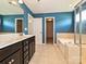 Bathroom featuring double sinks, a soaking tub, and a glass-enclosed shower with tile surround at 9027 Gray Willow Rd, Charlotte, NC 28227