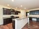 Kitchen featuring stainless steel appliances, granite countertops, a large island, and dark wood cabinets at 9027 Gray Willow Rd, Charlotte, NC 28227