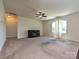 Living room featuring a ceiling fan, an electric fireplace, and natural light at 9027 Gray Willow Rd, Charlotte, NC 28227