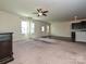 Spacious living room with ceiling fan, lots of natural light, and an open floor plan into the kitchen at 9027 Gray Willow Rd, Charlotte, NC 28227