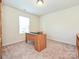Office featuring a large window, neutral carpet, and a built-in wooden desk at 9027 Gray Willow Rd, Charlotte, NC 28227