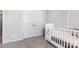 Bedroom with white crib, closet and patterned wallpaper for a cozy feel at 941 Rachel Anne Dr, Belmont, NC 28012