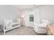 Neutral Bedroom with white crib, rocking chair, patterned wallpaper, and natural light at 941 Rachel Anne Dr, Belmont, NC 28012
