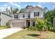 Traditional two-story home with a two-car garage, manicured lawn, and covered front porch in suburban neighborhood at 941 Rachel Anne Dr, Belmont, NC 28012
