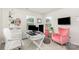 Bright home office with white desk, dual monitors, pink chairs, and a large window for natural light at 941 Rachel Anne Dr, Belmont, NC 28012
