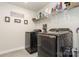 Modern laundry room with dark front load washer and dryer and wire shelving at 941 Rachel Anne Dr, Belmont, NC 28012