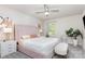 Bright main bedroom featuring carpet, ceiling fan, a plant, and a bed with a blush-pink headboard at 941 Rachel Anne Dr, Belmont, NC 28012