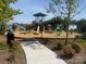 Community playground with slides, climbing structure, and various play features in a landscaped setting at 941 Rachel Anne Dr, Belmont, NC 28012